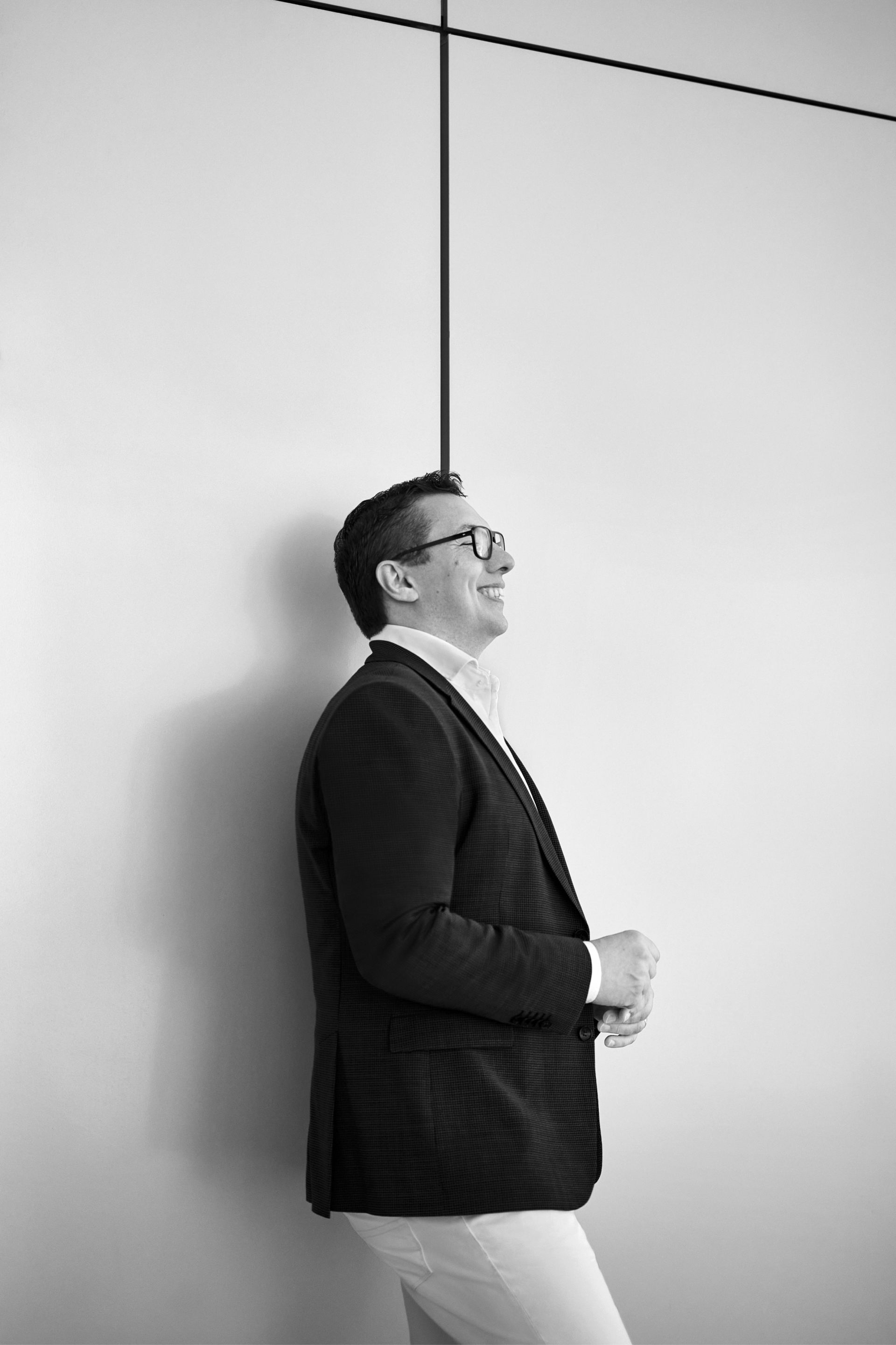 Giorgio Delucchi laughing in front of a white wall.