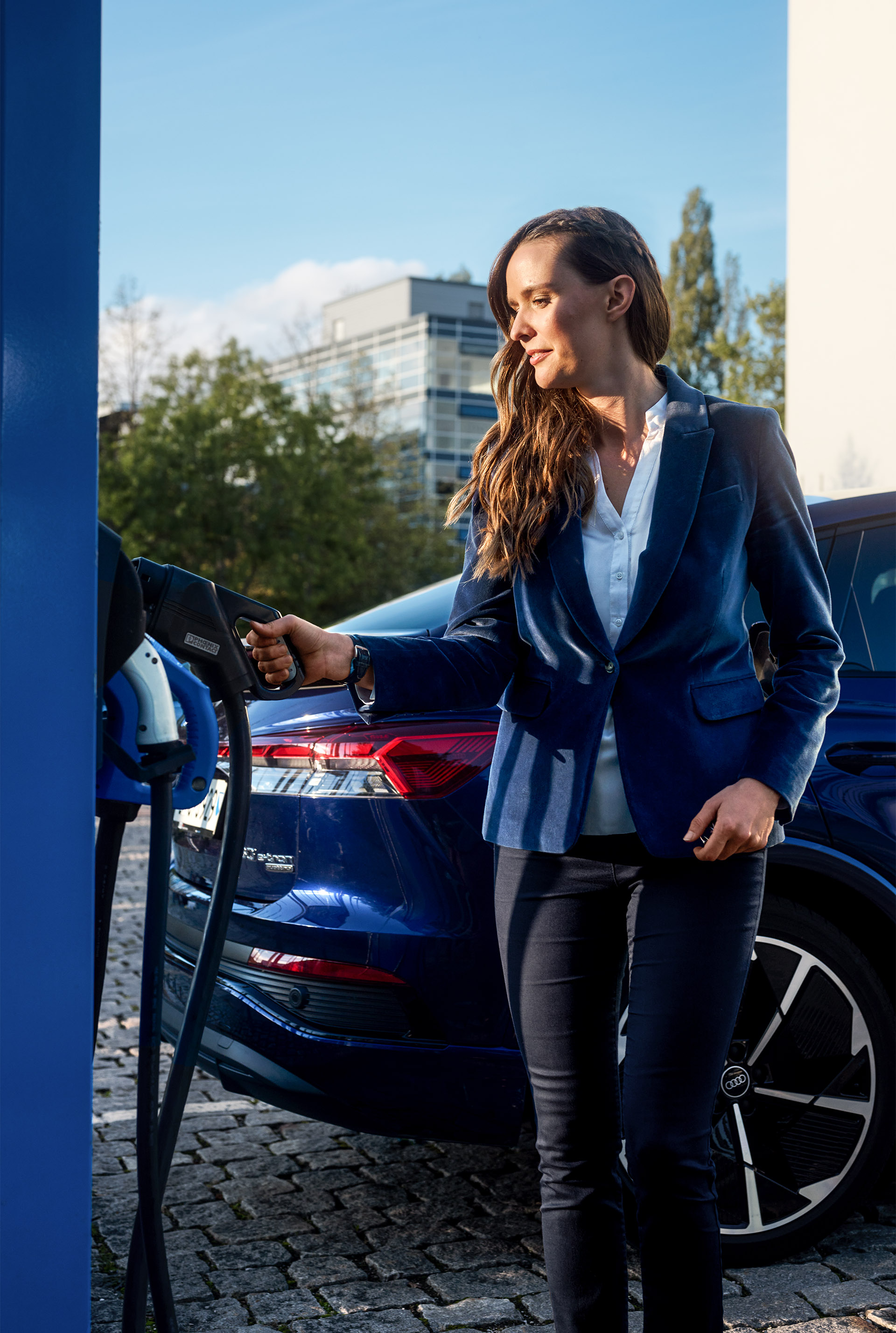 Sunnie Groeneveld at the charging station, her Audi Q4 Sportback e-tron in the background.