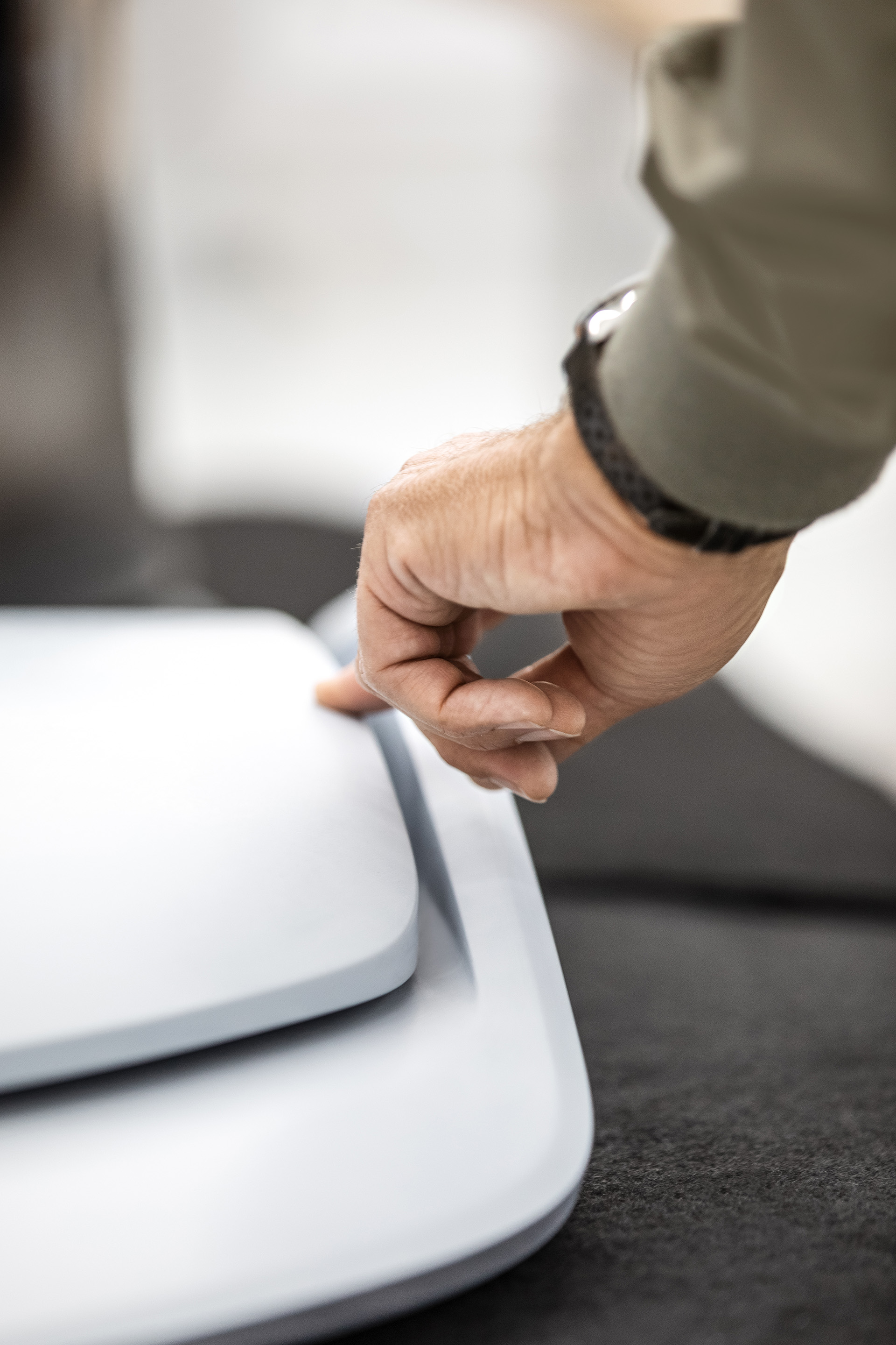 An index finger strokes a vehicle detail. 